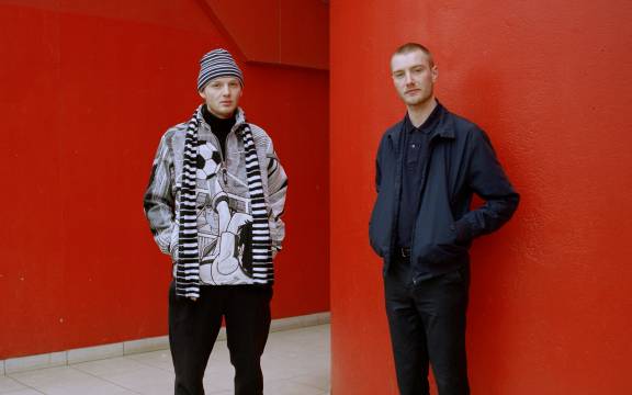 Twee mannen voor rode muur