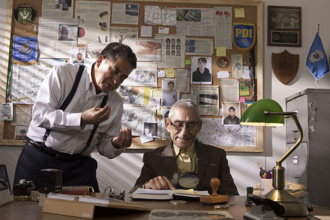 Een volwassen man en oude man bij een bureau